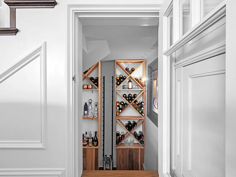 Wine cellar with refrigerator below the stairs