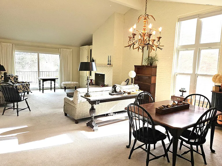 vaulted ceiling, brick accent wall, natural light, open floor plan