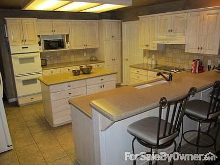 Solid surface countertops, tile floors, cabinets galore!