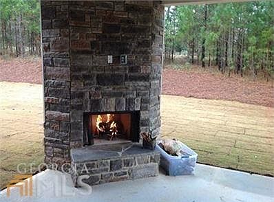 Our signature KDH-homes covered back patio with stacked stone outdoor fireplace.