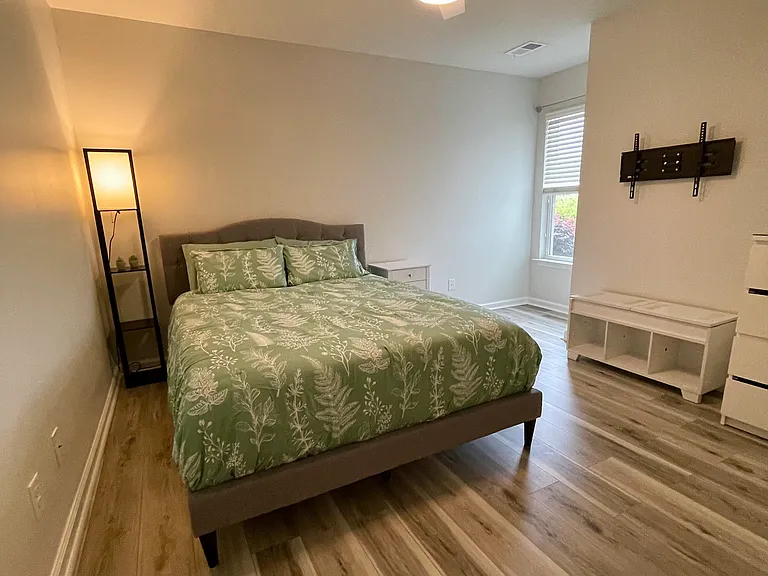 View from bedroom door. It is furnished presently & anything not needed will be stored elsewhere. The TV mount can accommodate up to a 65" TV.
