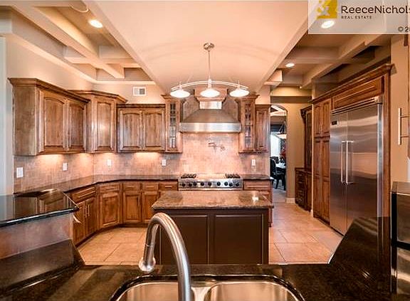 Chef's kitchen offers granite counters, commercial grade Viking appliances and a walk-in pantry.  Unique Coffered Ceiling Design shows the details of the builder's design.