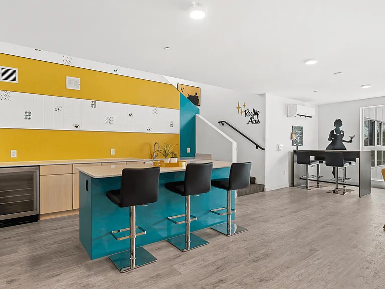 Modern rooftop lounge with entertainment kitchen and bar seating.