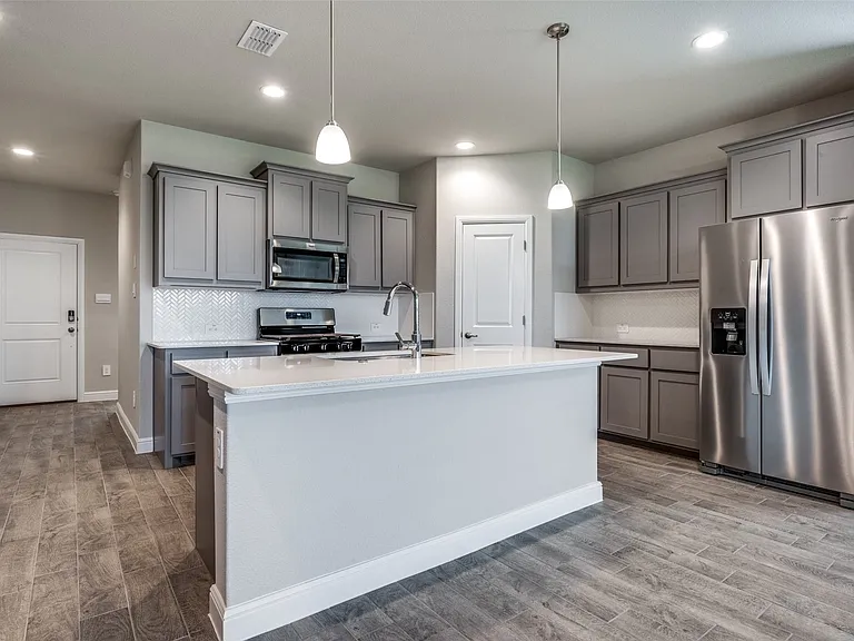 Kitchen with decorative light fixtures, stainless steel appliances, hardwood / wood-style floors, and tasteful backsplash