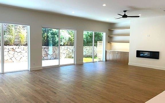 Grand room featuring beautiful hardwood floors, ceiling fan, and plenty of natural light which opens to back courtyard and side yard. Perfect for grilling!