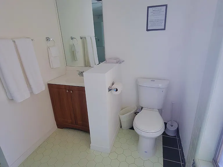 Bright bathroom featuring fresh towels, ventilation, and essential comforts.