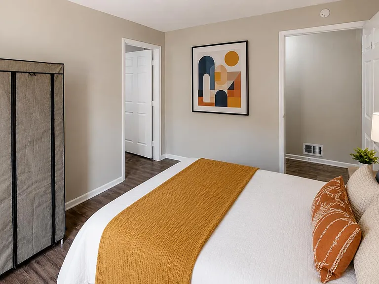 Furnished bedroom with a full bed setup, bedside lighting, and convenient closet/storage space for everyday use.