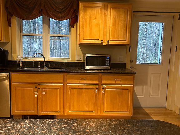 Kitchen cabinets and door to deck and backyard
