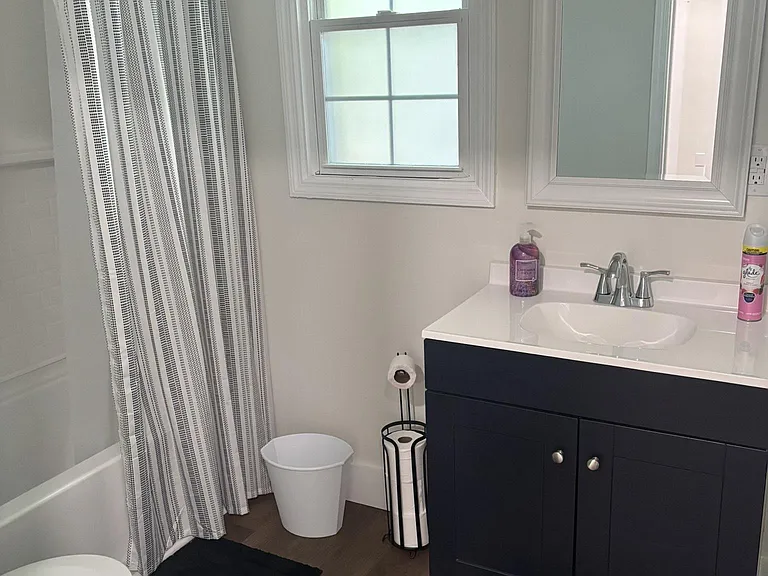 Well-appointed bathroom with a tub/shower combo, window for natural light, and a single-sink vanity with storage.