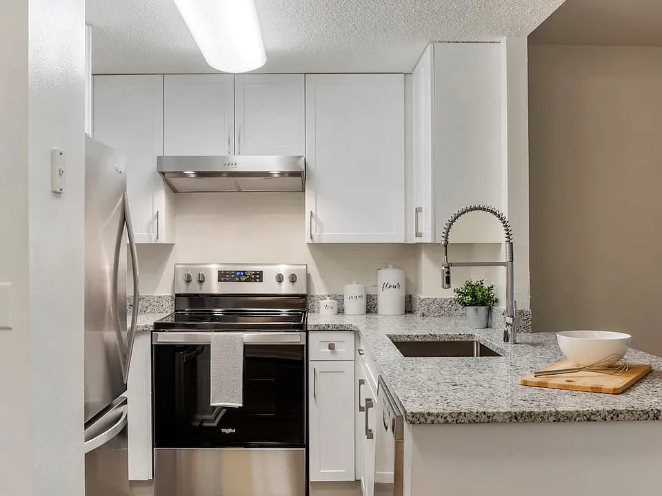Renovated Package II kitchen with white cabinetry, quartz countertops, stainless steel appliances, and hard surface flooring