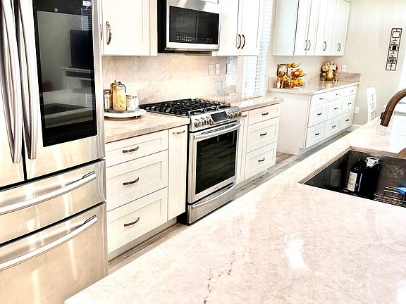 Kitchen: Upgraded appliances, natural quartzite stone waterfall island and countertops, soft close cabinets