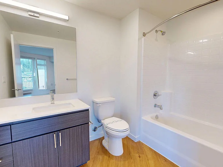 Apartment Bathroom with large soaking tub and wood-style flooring.