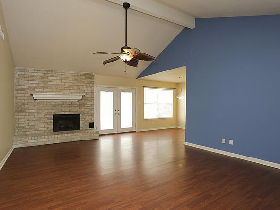 LIVING ROOM - View from entry area. The natural light illuminates this beautiful living room with high ceilings. Enjoy the gas burning fireplace on our cold nights. Laminate flooring throughout living and dining space.