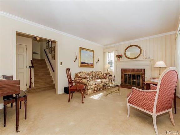 Living Room with architectural molding and wood floors under new carpeting
