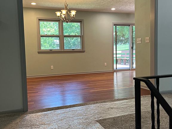 Top of stairs looking into kitchen and living room to the right. carpet protector still on new carpeting.