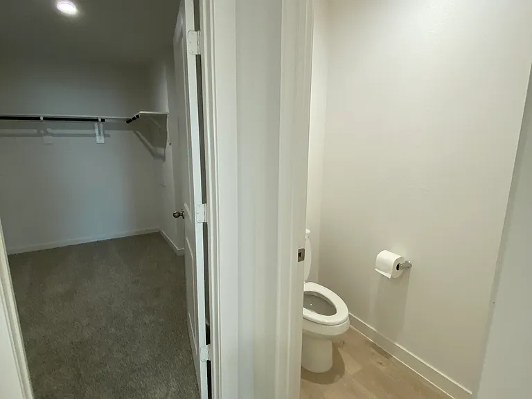Toilet and entrance to walk in closet in the master bathroom
