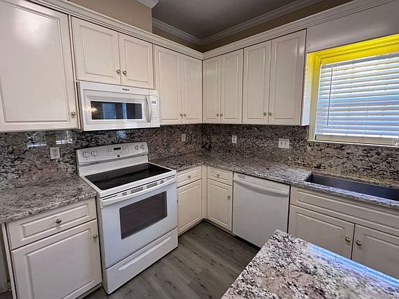 Kitchen with beautiful granite counter tops extending into the backsplash