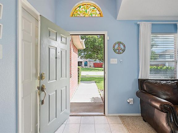 Entrance foyer with light tile patterned flooring and baseboards