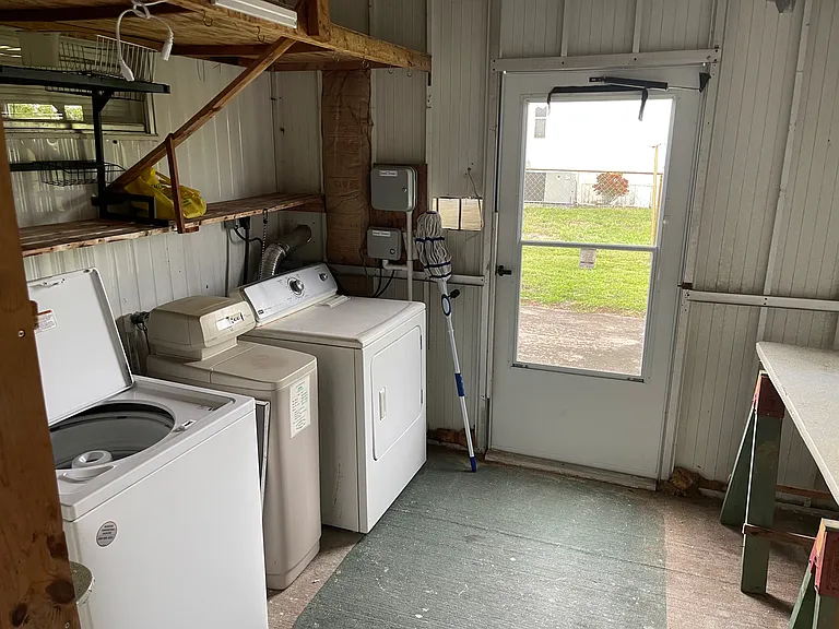 Laundry room with back door leading to fenced in backyard.