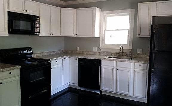 Renovated kitchen with new appliances including refrigerator