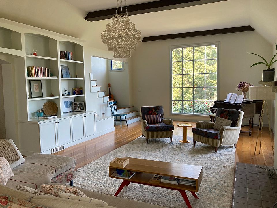 Living room, with high ceilings, piano and fireplace.