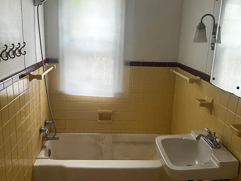 Full bath with refinished tub, new cabinet, and fresh paint.