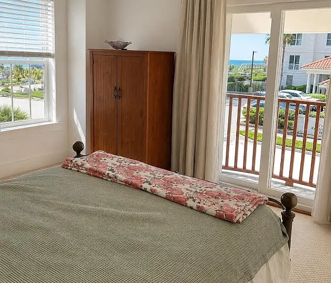 Upstairs bedroom facing east with ocean views and nearby full bath.