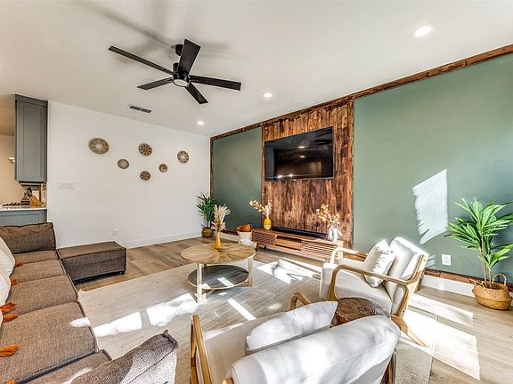 Living space featuring wood-finish flooring, recessed lighting, and a black ceiling fan