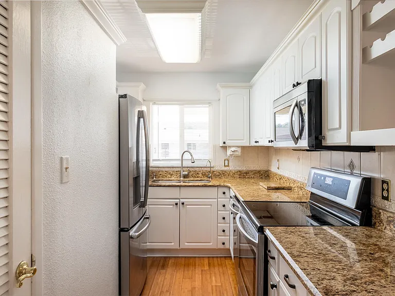 Stainless steel appliances, garbage,wine rack, disposal, electric can opener, water purification system at the sink. The window now has modern zebra blinds.