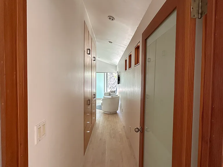 Private hallway with built in storage to master suite
