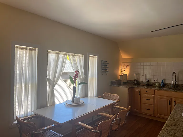 Dining Table in Kitchen, with corner view of East Wall to the left of the sink