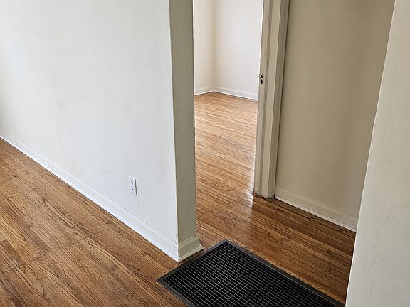 View from doorway of kitchen; living room area is to left in photo; Open door at end of hallway is to southwest bedroom