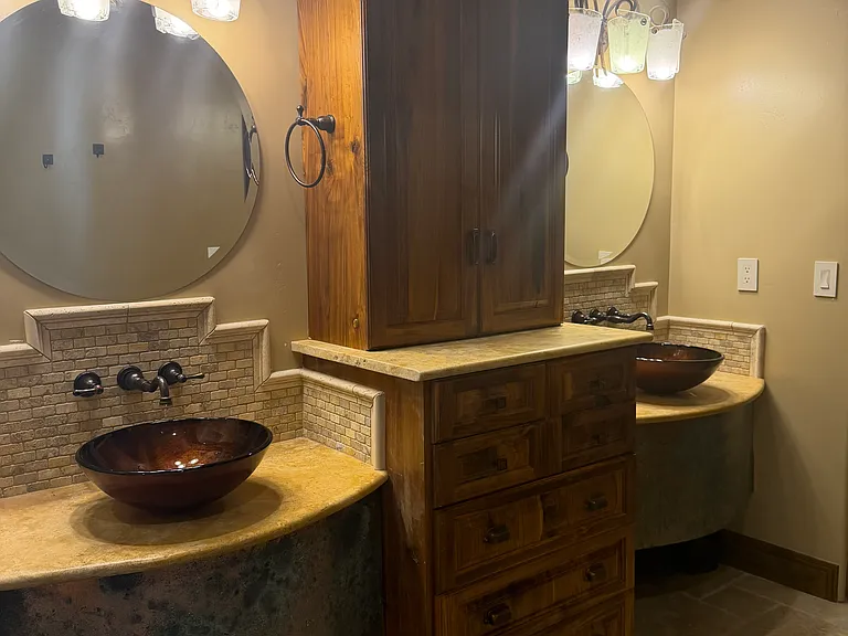 master bath with double vessel sinks and built in cabinets
