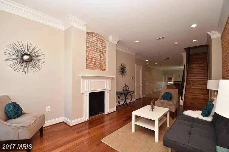 Spacious living room has so much charm with this decorative historic fireplace!
