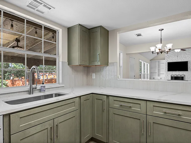 Newly renovated kitchen with gorgeous quartz countertops and sage green cabinets. The stove, dishwasher, and fixtures are all new and premium quality.