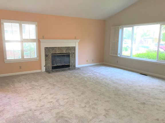 Living room with a fireplace and large windows.