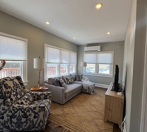 Living room with natural light, large screen, ROKU Smart TV.