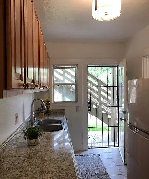 Kitchen has door to the shared backyard and laundry room.