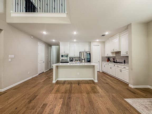 Completely uniform kitchen anchors open-concept living and dining breakfast area