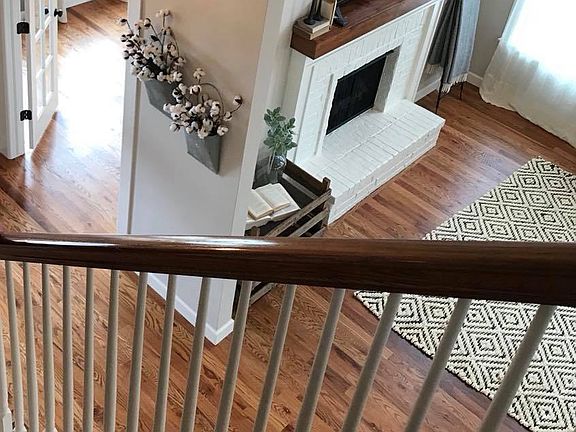 Staircase with view of living room and entry to study