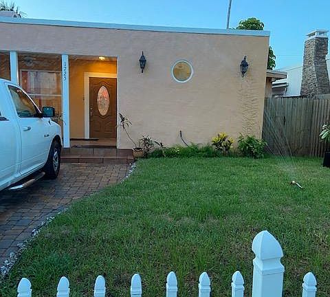 Front of the house with lawn and 2 car parking.