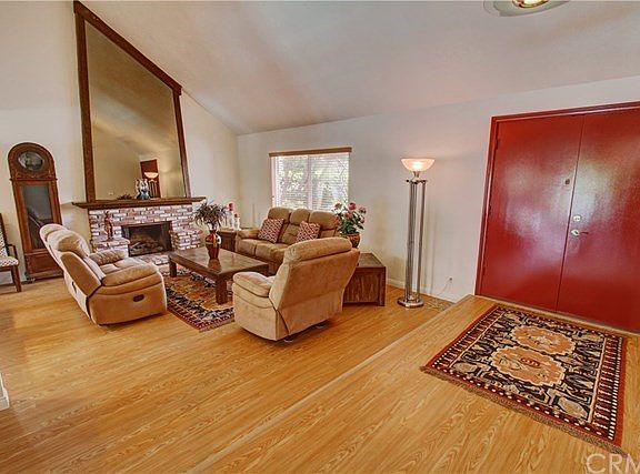 A spacious Living Room with custom brick fireplace and wooden mantle. The cathedral textured ceilings give an open, light and airy ambience to this room.