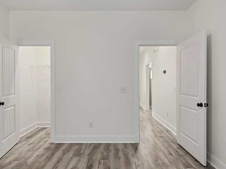 Guest bedroom doors leading into private closet and hallway