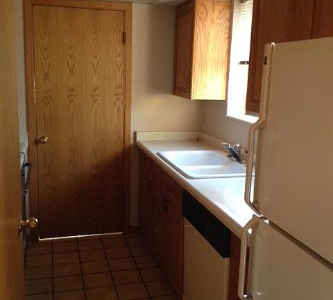 Kitchen facing door to laundry room, half bath, and garage