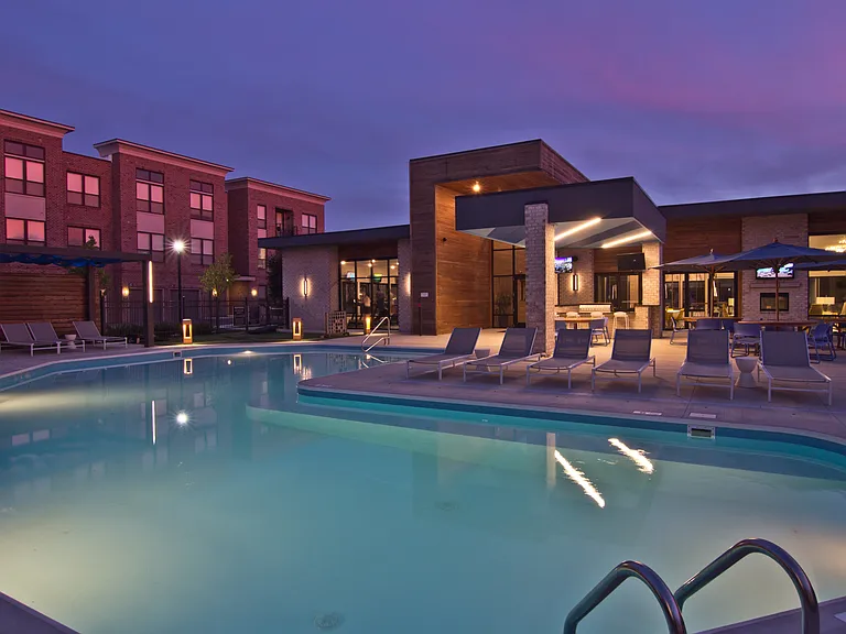 Swimming pool with lounge chairs at dusk