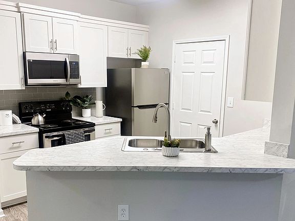 Carrara-marble inspired countertops add a touch of flair and style to select apartment kitchens.