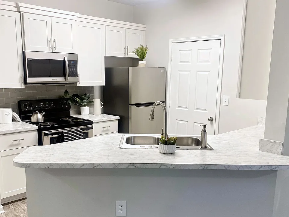Carrara-marble inspired countertops add a touch of flair and style to select apartment kitchens.