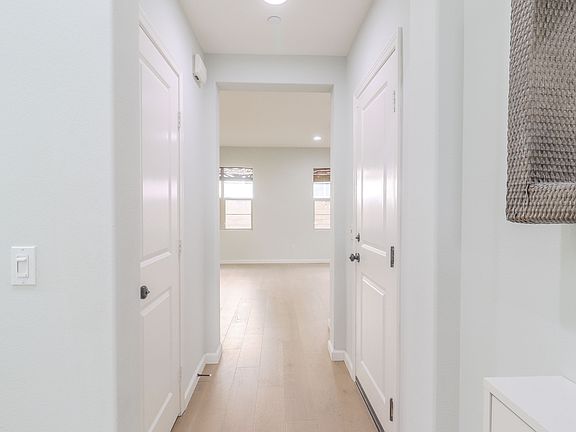 Foyer leading to the kitchen/dining area. (Storage door to the left. Garage door to the right)