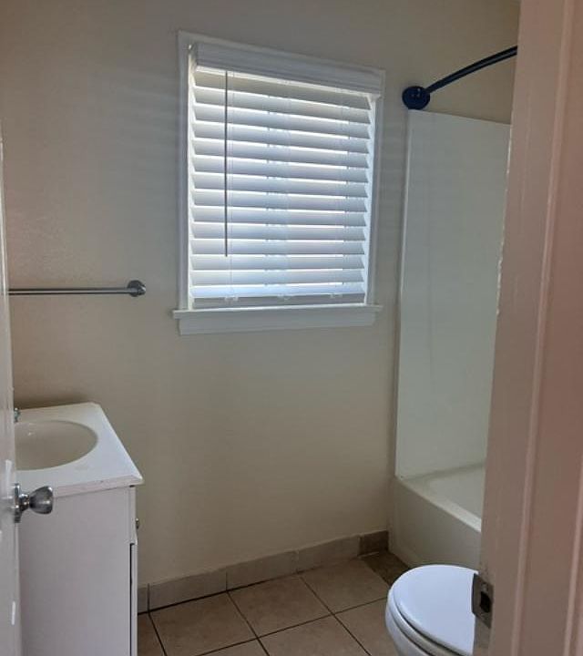 Bathroom with full bathtub and tile flooring
