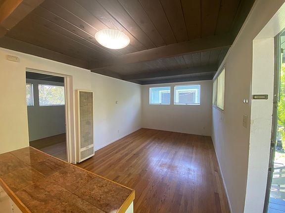 Looking into apartment at front door, showing beamed ceiling.